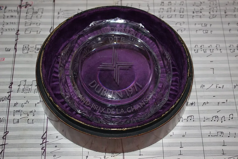Gläserne Trophäe des Grand Prix Eurovision 1971 in Dublin auf Notenblättern