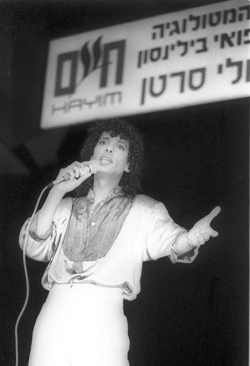 Izhar Cohen singt mit Mikrofon und ausgestrecktem Arm auf einer Bühne in Israel, 1987