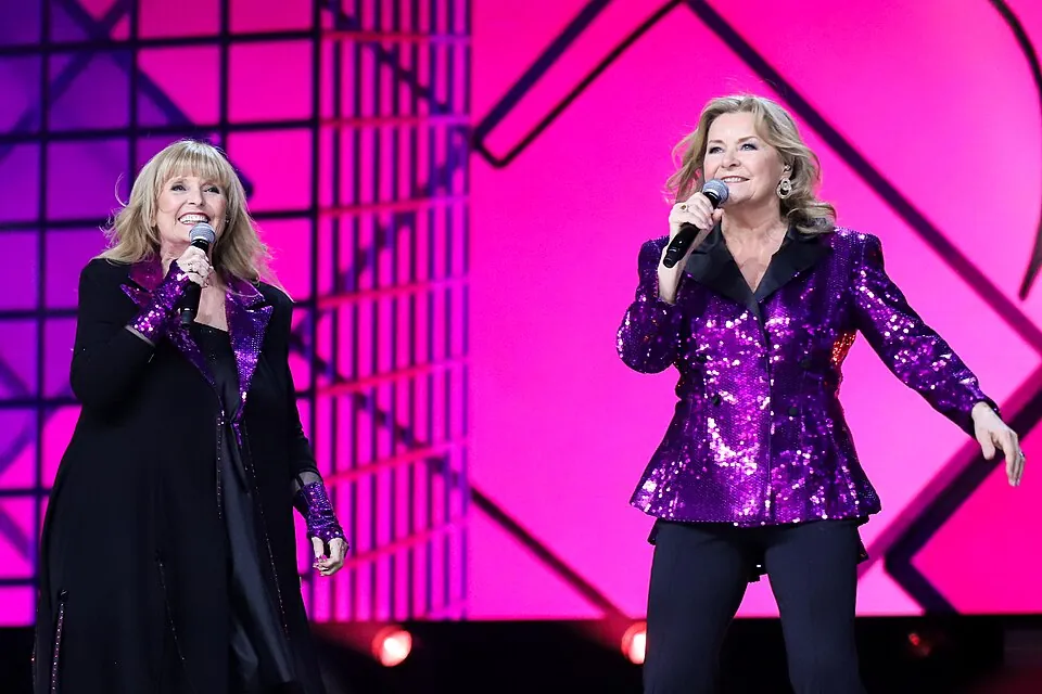 Hanne Krogh und Elisabeth Andreassen von Bobbysocks singen in Glitzerjacken auf der MGP-Bühne 2025
