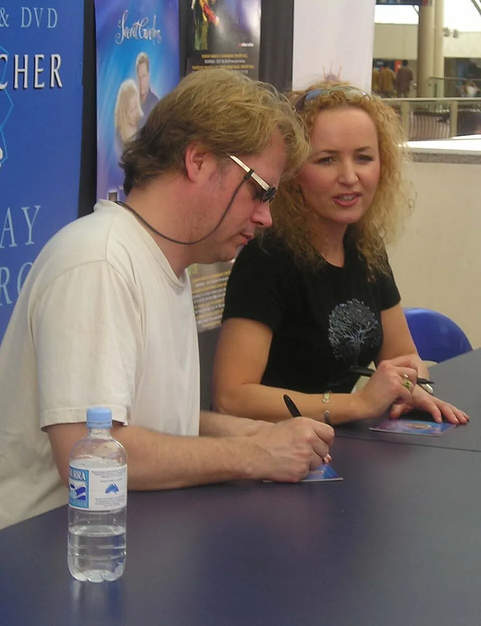 Rolf Løvland und Fionnuala Sherry von Secret Garden geben an einem Tisch Autogramme, 2008