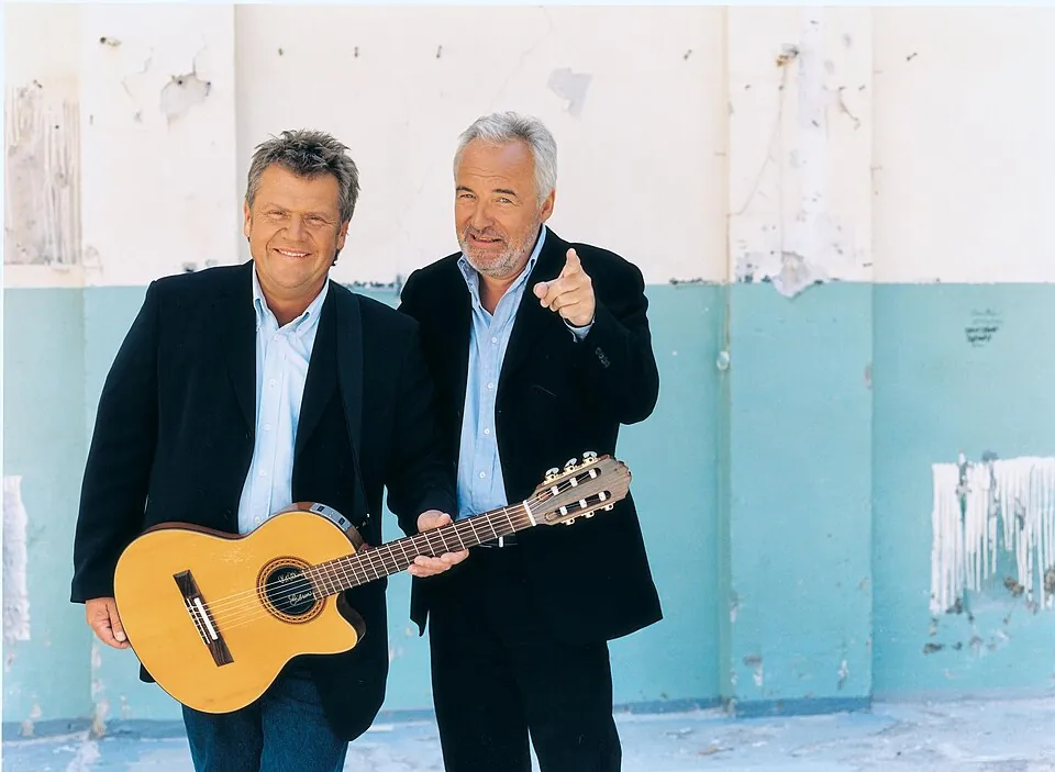 Die Brüder Jørgen und Niels Olsen mit Akustikgitarre vor einer verwitterten Wand, 2008