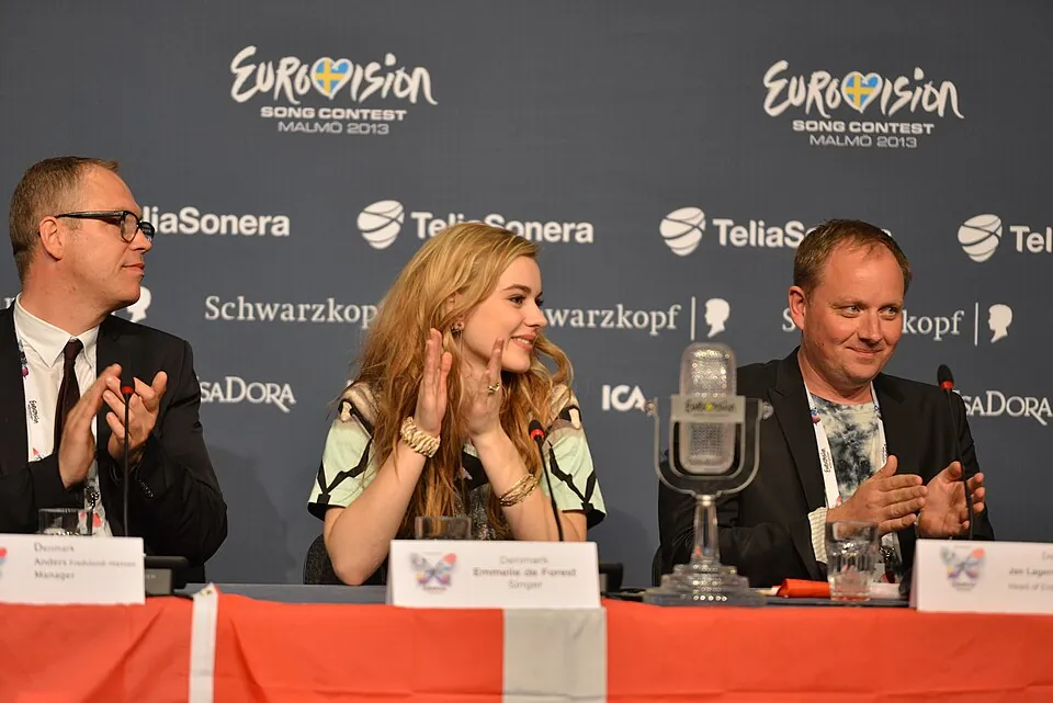 Emmelie de Forest applaudiert zwischen zwei Männern am Pressekonferenztisch mit Trophäe, ESC 2013