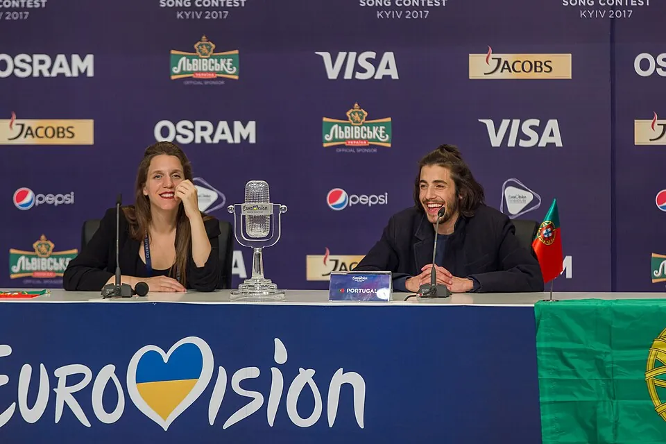 Luísa und Salvador Sobral am Pressekonferenztisch mit Siegertrophäe und portugiesischer Flagge, 2017