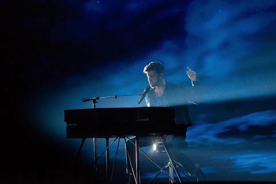Duncan Laurence singt am Flügel vor blau-wolkiger Bühnenkulisse, Generalprobe ESC 2019