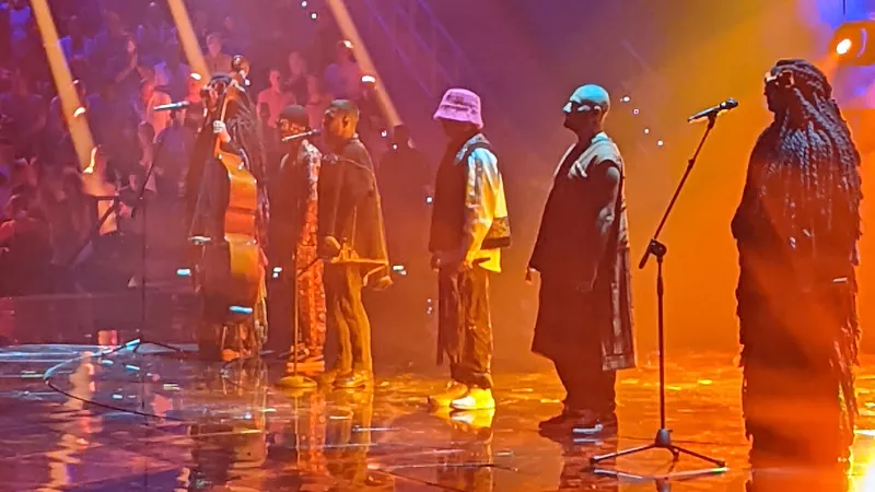 Kalush Orchestra in traditioneller Kleidung und pinkem Hut auf der ESC-Bühne in Turin, 2022