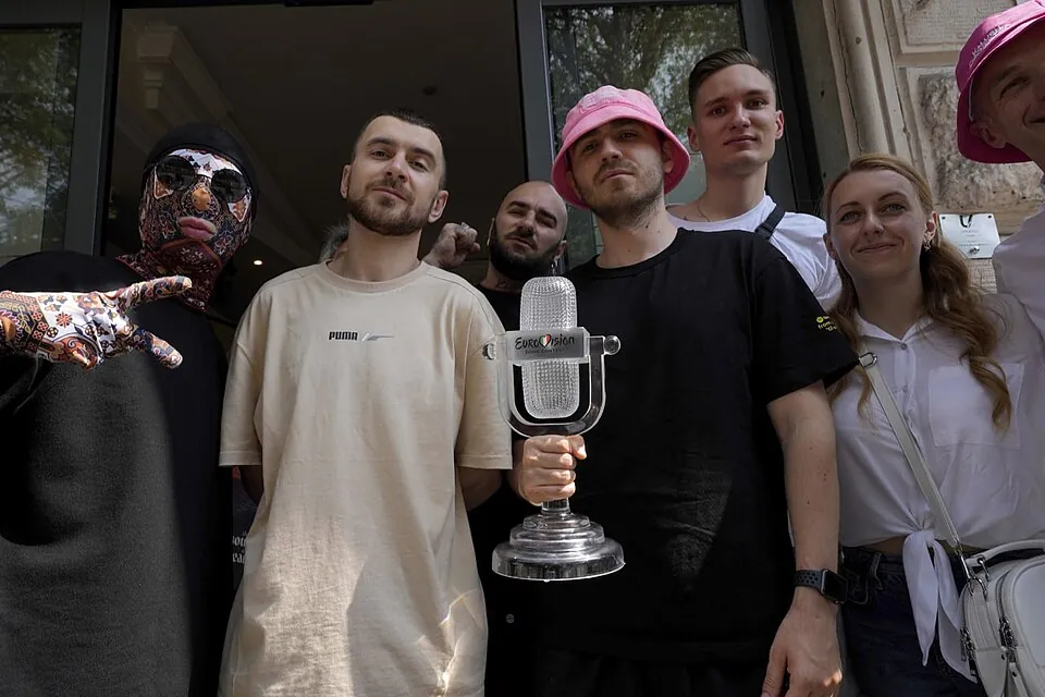 Mitglieder von Kalush Orchestra posieren mit der gläsernen Mikrofon-Trophäe des ESC 2022